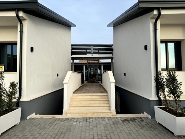 Facciata moderna bianca con scala centrale.