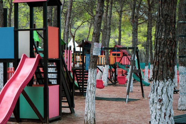 Parco giochi colorato tra gli alberi.