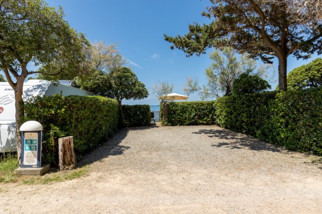 Spiazzo alberato con vista sul mare.