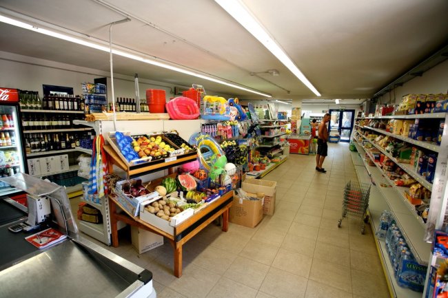 Interno di un negozio con scaffali pieni di prodotti.