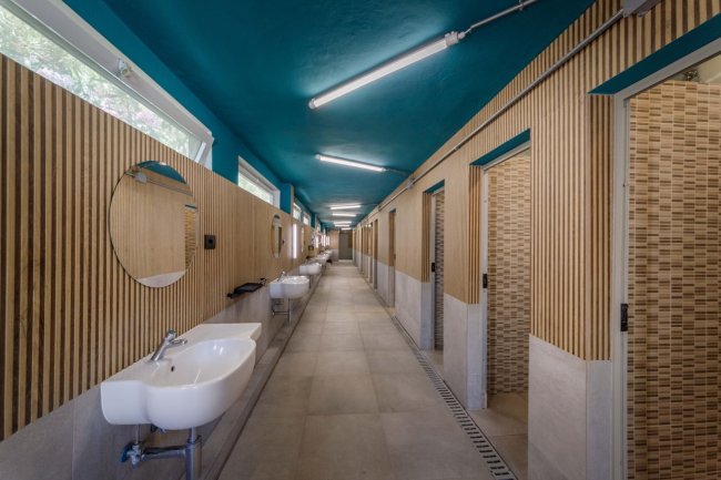 Corridoio di bagni pubblici con lavandini e specchi.