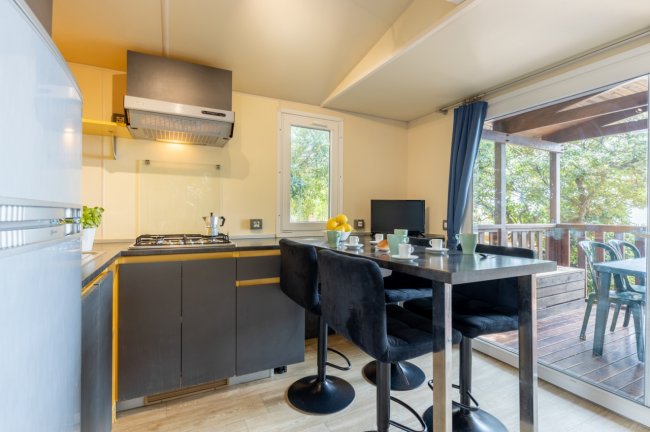 Cucina moderna con bancone e sgabelli neri.
