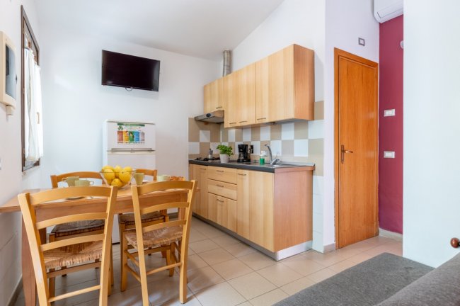 Cucina tradizionale con tavolo e sedie in legno.