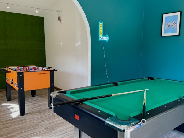 Sala giochi con tavolo da biliardo e calciobalilla.