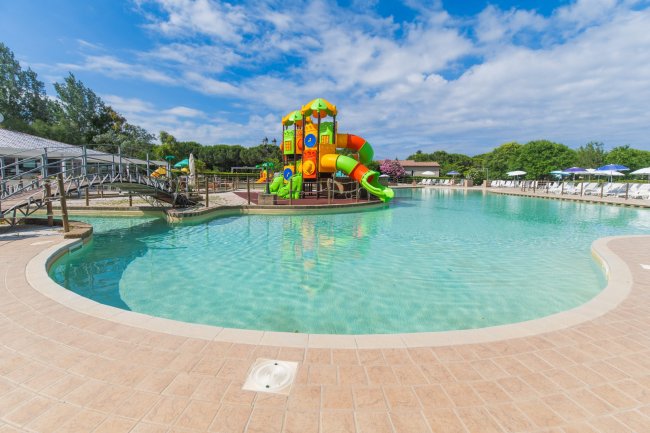 Piscina con scivoli colorati e cielo sereno.