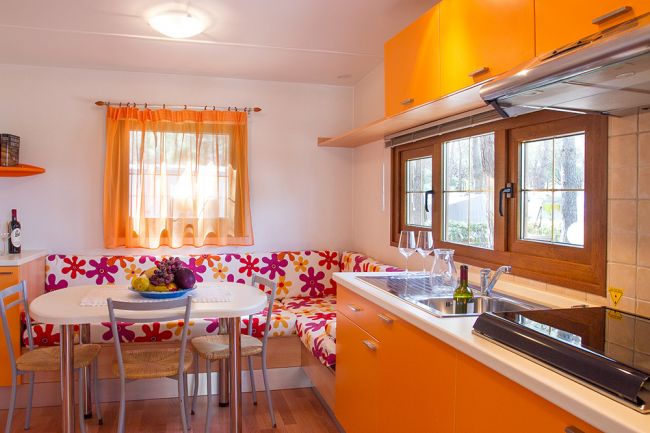Cucina moderna con arredamento arancione e finestra.