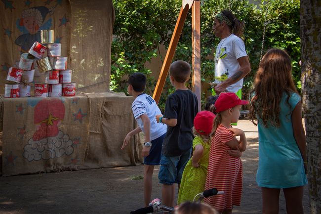 Bambini che osservano una scena di barattoli in un parco giochi all'aperto.