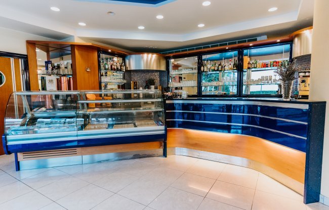 Interno di un bar moderno con bancone blu.