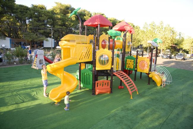 Parco giochi colorato con scivoli e strutture per bambini.