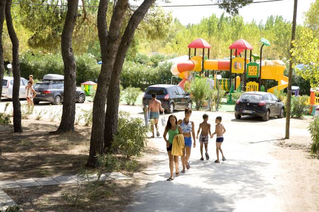Famiglia cammina vicino a un parco giochi.