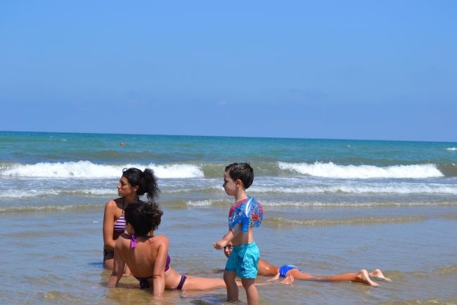 Persone rilassate in mare con onde leggere.