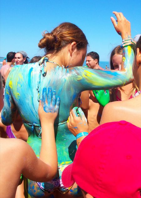 Ragazza dipinta di blu al sole su una spiaggia.