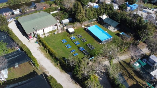Veduta aerea di un campo con piscina e lettini.