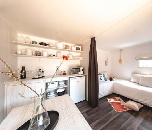 Angolo cucina con letto singolo in vista.