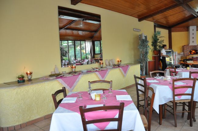 Interno di un ristorante con tavoli apparecchiati e tovaglie rosa.