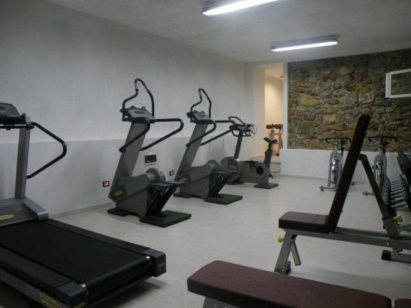 Palestra con attrezzature sportive, tra cui tapis roulant e cyclette.