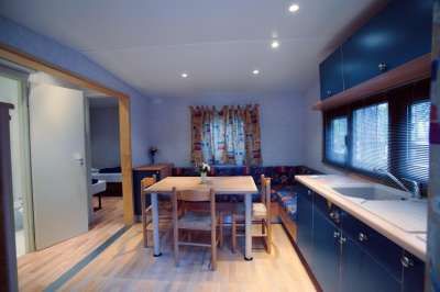 Interno di una cucina con tavolo da pranzo e sedie, mobili blu.