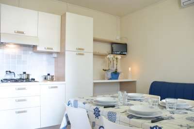 Cucina moderna con tavolo apparecchiato e decorazioni blu.
