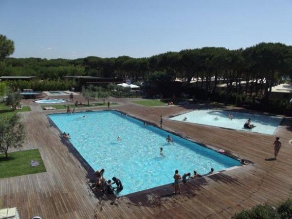 Piscina rettangolare e altre vasche su piattaforma di legno.