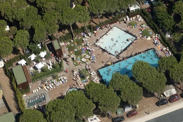 Vista dall'alto di piscine con persone e ombrelloni.