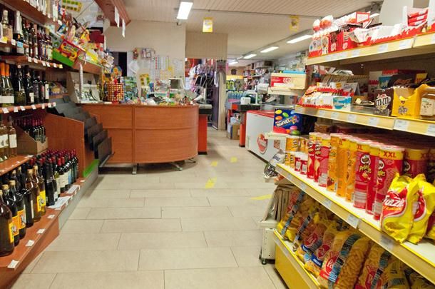 Corsia di un negozio con scaffali di snack e bottiglie di vino.