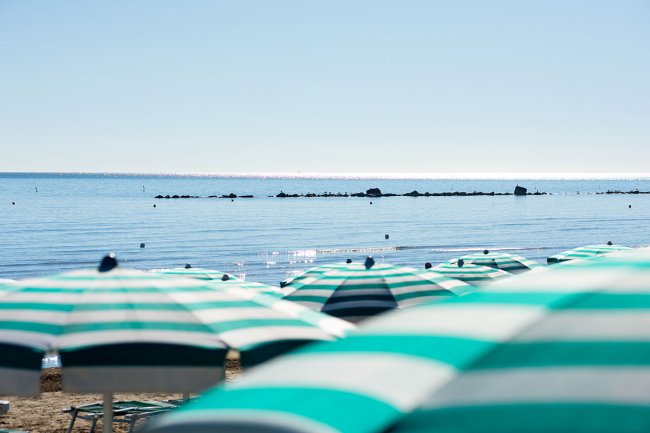 Ombrelloni fronte mare con onde leggere.
