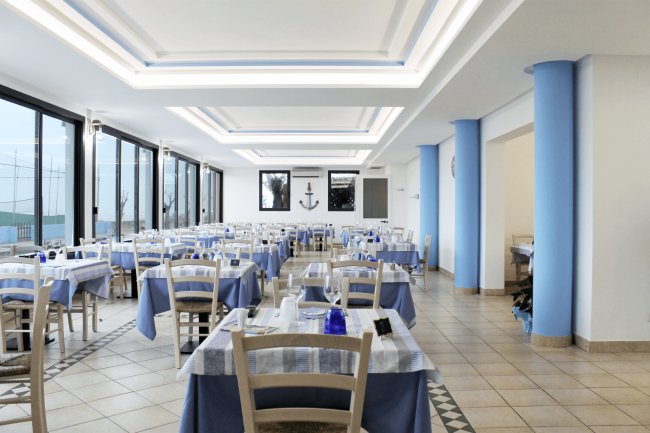 Sala ristorante con tavoli coperti di tovaglie blu.