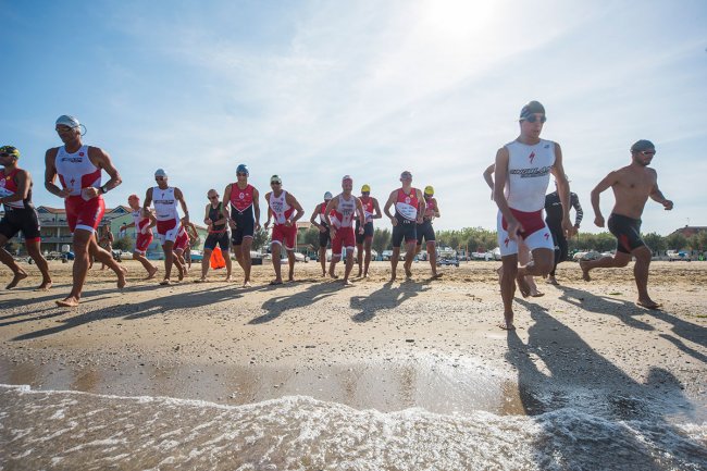 Persone che corrono sulla spiaggia vicino all'acqua.
