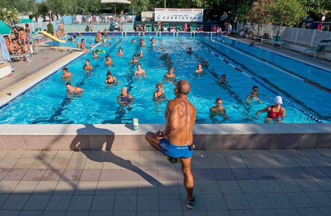 Allenatore davanti a gruppo in acqua in una piscina.