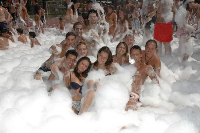 Un gruppo di persone si diverte in una festa di schiuma all'aperto.