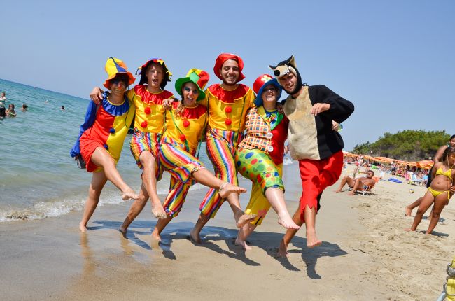 Persone in costumi colorati sulla spiaggia.