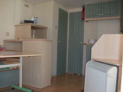 Interno con ripiani in legno, porte verdi e riscaldamento a parete.