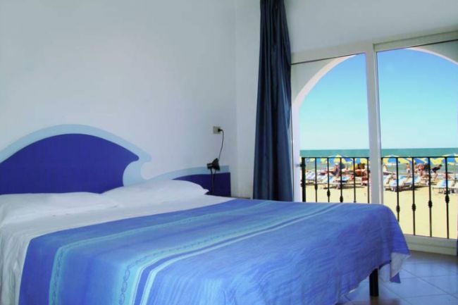 Camera vista mare, letto e vetrata.