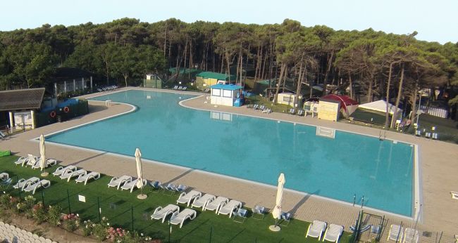Grande piscina con lettini attorno.