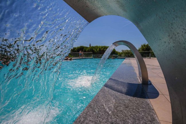 Cascata d'acqua in una piscina soleggiata.