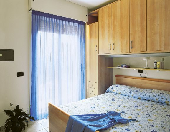 Camera da letto con tende blu e letto matrimoniale.