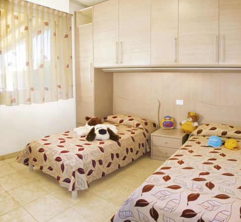 Camera con due letti singoli e peluche.