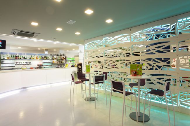 Bar moderno con bancone e sedie alte.