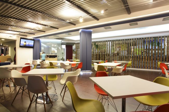 Sala caffetteria con sedie colorate.