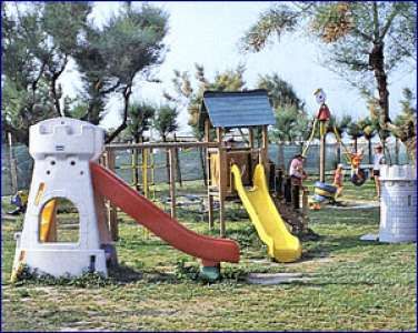 Parco giochi con scivoli colorati e alberi sullo sfondo.
